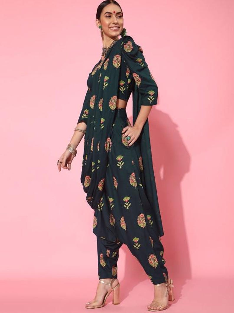 May include: A dark green printed crop top and matching dhoti pants with a floral design. The outfit is made of a soft, flowing fabric and has a relaxed fit.