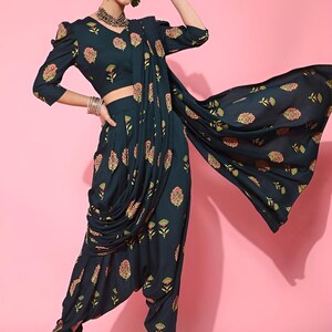 May include: A teal blue printed dhoti pant and crop top set with a matching printed dupatta. The outfit features a floral print in shades of pink, green, and gold.