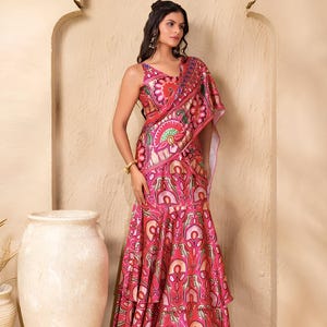 May include: A vibrant pink and red patterned formal dress with a matching shawl. The dress features a sleeveless top and a tiered, flared skirt. The intricate design includes floral and geometric elements. The outfit is suitable for special occasions.