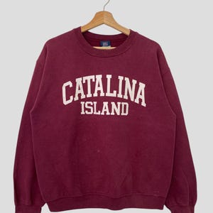 May include: A maroon sweatshirt with the text "Catalina Island" printed in white on the front.
