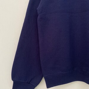 May include: A navy blue long-sleeved sweatshirt with a ribbed hem and cuffs.