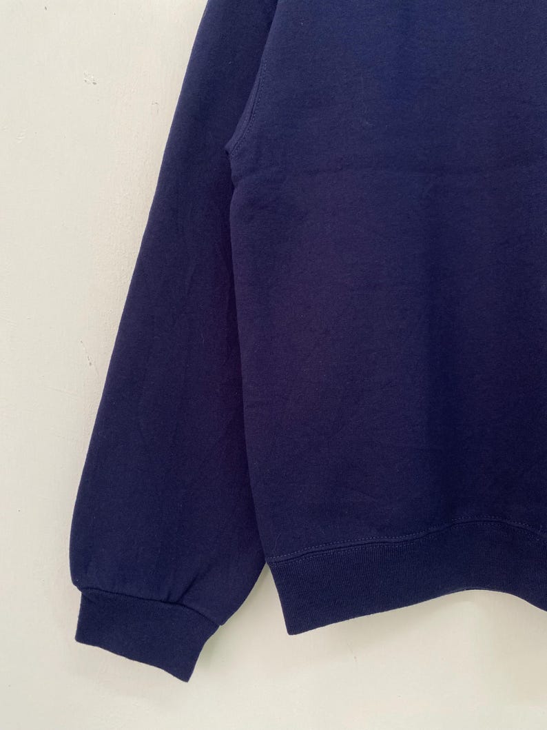 May include: A navy blue long-sleeved sweatshirt with a ribbed hem and cuffs.