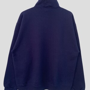 May include: A dark blue, long-sleeved sweatshirt with a mock neck and zipper closure.