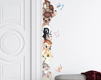 May include: A white door with a decorative design is partially open, revealing a wall with a series of cartoon animal stickers. The stickers feature a brown owl, a fawn, a skunk, a rabbit, and a bird. The stickers are arranged vertically, with the owl at the top and the bird at the bottom.