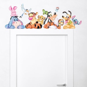 May include: A wall decal featuring a group of Disney characters, including Winnie the Pooh, Tigger, Simba, Goofy, Pluto, and Stitch. The characters are arranged in a row, with their heads facing the viewer. The decal is printed on a white background.