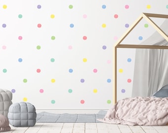 Puede incluir: Una pared blanca con un patrón de lunares coloridos. Los lunares son de varios colores pastel, incluyendo rosa, azul, verde y amarillo. Un marco de cama de madera con un dosel blanco está en primer plano.