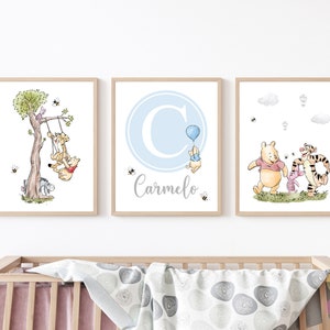 K&ouml;nnte beinhalten: Drei Winnie-the-Pooh-Kinderzimmerdrucke in einem blauen und grauen Farbschema. Der erste Druck zeigt Winnie Puuh, Ferkel und Tiger auf einer Schaukel. Der zweite Druck zeigt den Buchstaben C in einem blauen Kreis mit dem Namen Carmelo darunter. Der dritte Druck zeigt Winnie Puuh, Ferkel und Tiger, die zusammen gehen.