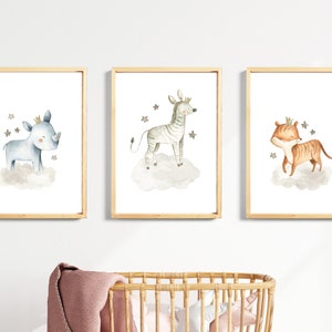 May include: Three framed watercolor illustrations of animals wearing crowns. The first illustration features a blue rhinoceros on a cloud with stars. The second illustration features a zebra on a cloud with stars. The third illustration features a tiger on a cloud with stars.