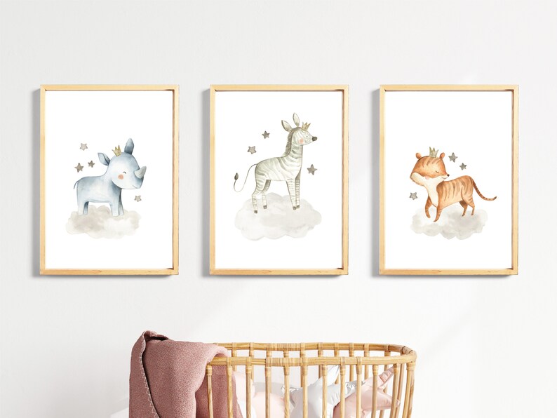 May include: Three framed watercolor illustrations of animals wearing crowns. The first illustration features a blue rhinoceros on a cloud with stars. The second illustration features a zebra on a cloud with stars. The third illustration features a tiger on a cloud with stars.