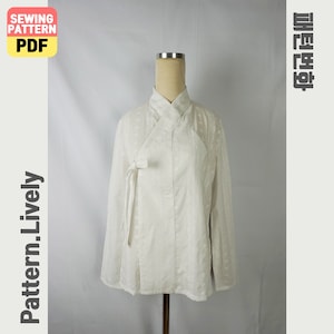 Puede incluir: Una blusa blanca de manga larga con cierre cruzado y bordado floral. La blusa se muestra en un maniquí. La imagen incluye el texto "SEWING PATTERN PDF" y "Pattern.Lively".