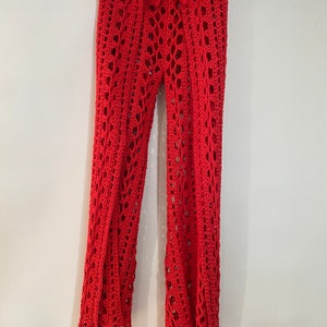 May include: Red crochet pants with a wide leg and a tie at the waist.