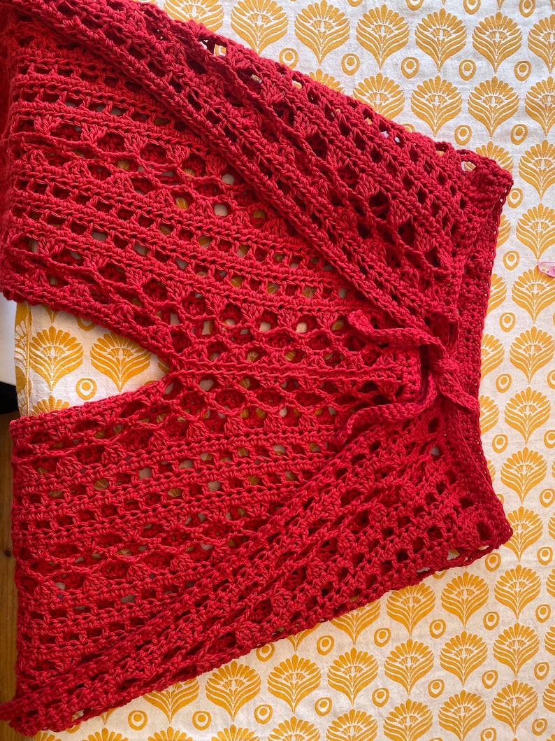 May include: Red crochet pants with a loose, flowy fit. The pants have a wide leg and a tie at the waist.