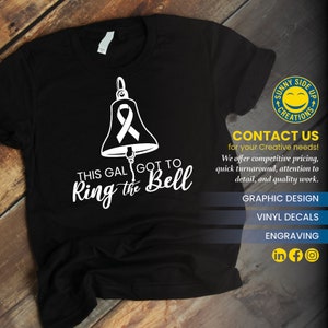 Op de afbeelding: Zwart T-shirt met een witte afbeelding van een bel met een lint en de tekst "This gal got to ring the bell". Het shirt heeft ook een logo voor Sunny Side Up Creations en contactgegevens voor grafisch ontwerp, vinyl stickers en graveerdiensten.