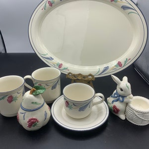 May include: A set of vintage floral patterned ceramic dishes, including a large oval serving platter, two mugs, a small sugar bowl shaped like a pear, a small teacup and saucer, a small bunny figurine, and a small basket.
