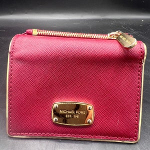 Cartera mediana Dillion de Michael Kors con tres pliegues en piel granulada color burdeos y detalles dorados