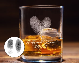 Puede incluir: Un vaso de vidrio transparente con un diseño de huella dactilar en forma de corazón y el texto "Andy y Selena 18/12/2019". El vaso está lleno de líquido ámbar y cubitos de hielo.