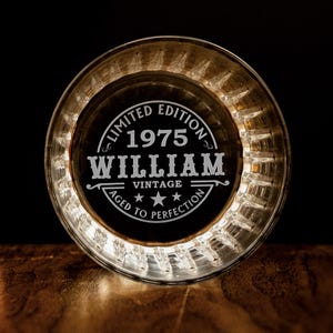 May include: A clear glass coaster with a white engraved design that reads "Limited Edition 1975 William Vintage Aged to Perfection".