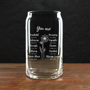 May include: A clear glass can-shaped drinking glass with the words "You are" and inspirational words like "Beautiful", "Amazing", and "Always Loved" in white script. A floral design is also included.