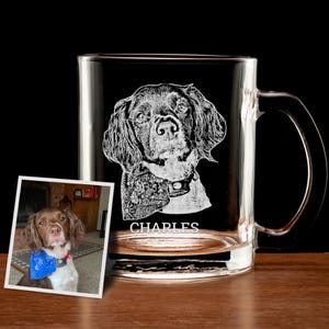 May include: A clear glass mug with a white etched image of a dog and the name "CHARLES" underneath. The dog is brown and white with floppy ears.