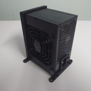 K&ouml;nnte beinhalten: Ein schwarzes Computer-Netzteil mit einem gro&szlig;en L&uuml;fter auf der R&uuml;ckseite. Das Ger&auml;t verf&uuml;gt &uuml;ber ein schwarzes Netzkabel und einen schwarzen Metallrahmen.