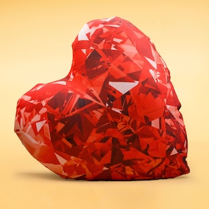 May include: A red heart-shaped cushion with a diamond-like pattern. The cushion is made of a soft, plush fabric and is perfect for adding a touch of love to any room.