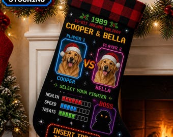 Puede incluir: Un calcetín navideño negro con un puño de cuadros rojos y negros. El diseño presenta gráficos de arcade de 16 bits, incluyendo dos perros golden retriever con gorros de Papá Noel llamados Cooper y Bella, barras de salud y el texto Insert Treat To Continue.