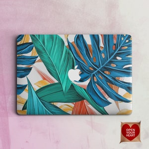 Puede incluir: Una piel para portátil con un diseño de hojas tropicales. El diseño presenta grandes hojas azules con hojas verdes y naranjas más pequeñas. La piel es blanca con una textura sutil.