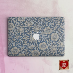 May include: A blue laptop skin with a beige floral pattern. The skin has a vintage aesthetic and features a repeating pattern of flowers and leaves.