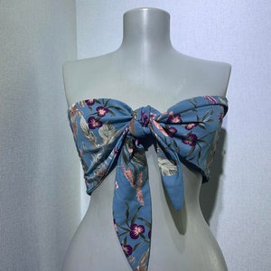 May include: A blue floral print bandeau top with a bow tie at the front.