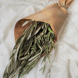 May include: A bouquet of dried olive branches wrapped in brown paper with twine.