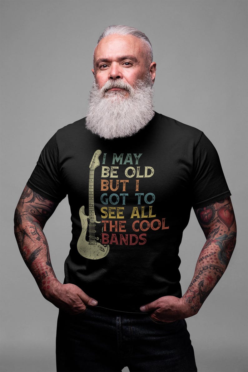 May include: A black t-shirt with a vintage-style graphic of a guitar and the text "I may be old but I got to see all the cool bands".