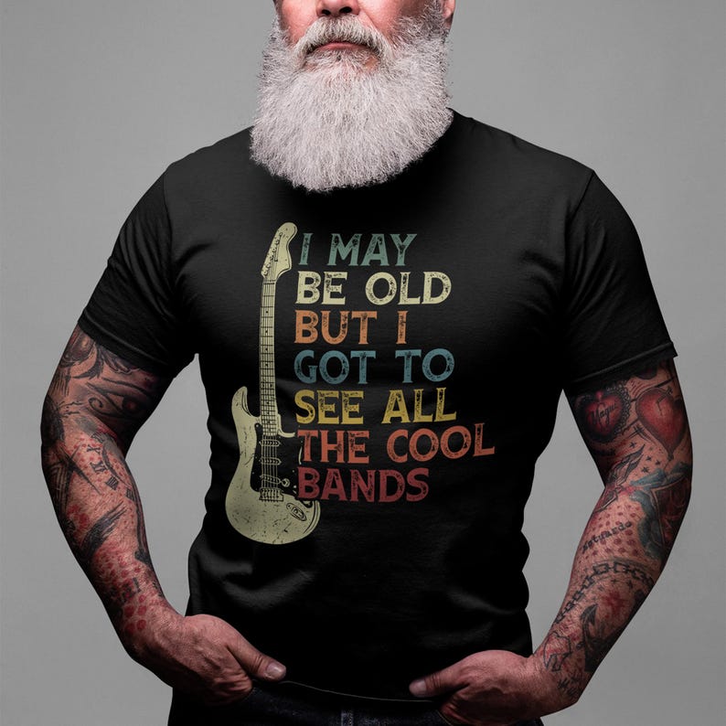 May include: A black t-shirt with a vintage-style graphic of an electric guitar and the text "I may be old but I got to see all the cool bands".