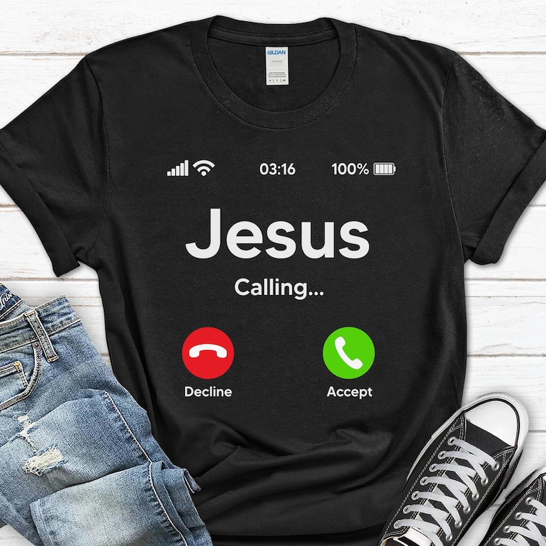 May include: Black t-shirt with a white phone screen graphic that says "Jesus Calling..." with a red decline button and a green accept button.