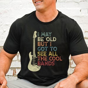 May include: Black t-shirt with a vintage-style graphic of an electric guitar and the text "I may be old but I got to see all the cool bands".