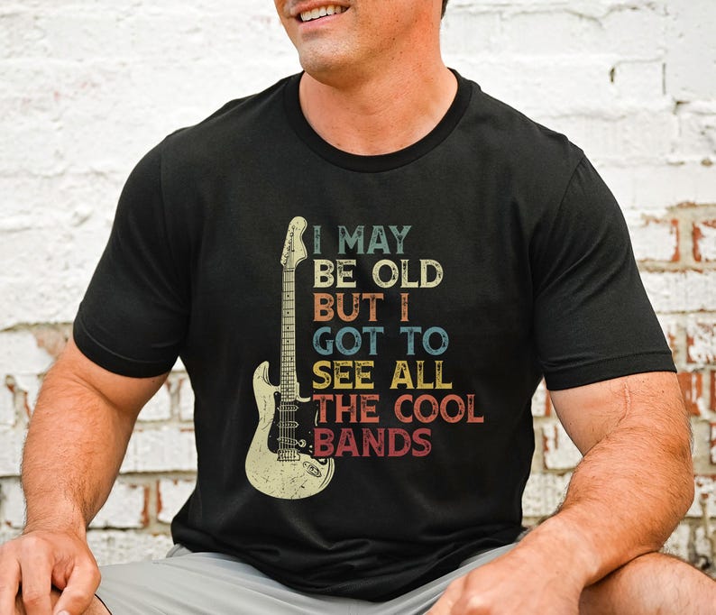 May include: Black t-shirt with a vintage-style graphic of an electric guitar and the text "I may be old but I got to see all the cool bands".