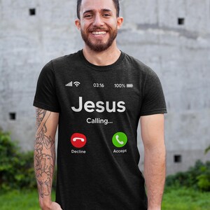 May include: Black t-shirt with a white graphic of a phone screen displaying "Jesus Calling..." with a red decline button and a green accept button.