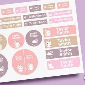 Puede incluir: Una hoja de etiquetas adhesivas con el nombre Taylor Smith en texto blanco. Las pegatinas vienen en varias formas rectangulares y circulares, coloreadas en tonos rosa, beige y marrón, y decoradas con ilustraciones de unicornios y nubes.