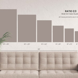 May include: A wall art size guide with a 2:3 ratio, displaying various rectangular canvas sizes in inches. Sizes range from 8" x 12" to 24" x 36". The text "RATIO 2:3 Wall Art Size Guide" is displayed. A beige sofa is in the foreground.