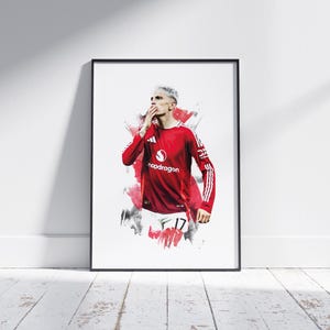 Könnte beinhalten: Eine digitale Illustration eines Fußballspielers in einem roten Trikot mit weißen Akzenten und einem weißen und schwarzen Trikot darunter. Der Spieler trägt weiße Shorts und schwarze Socken. Der Spieler schaut zur Seite und hat eine Hand am Mund. Das Trikot trägt den Text "Snapdragon" auf der Vorderseite. Der Hintergrund ist ein weißes und rotes Aquarelldesign.