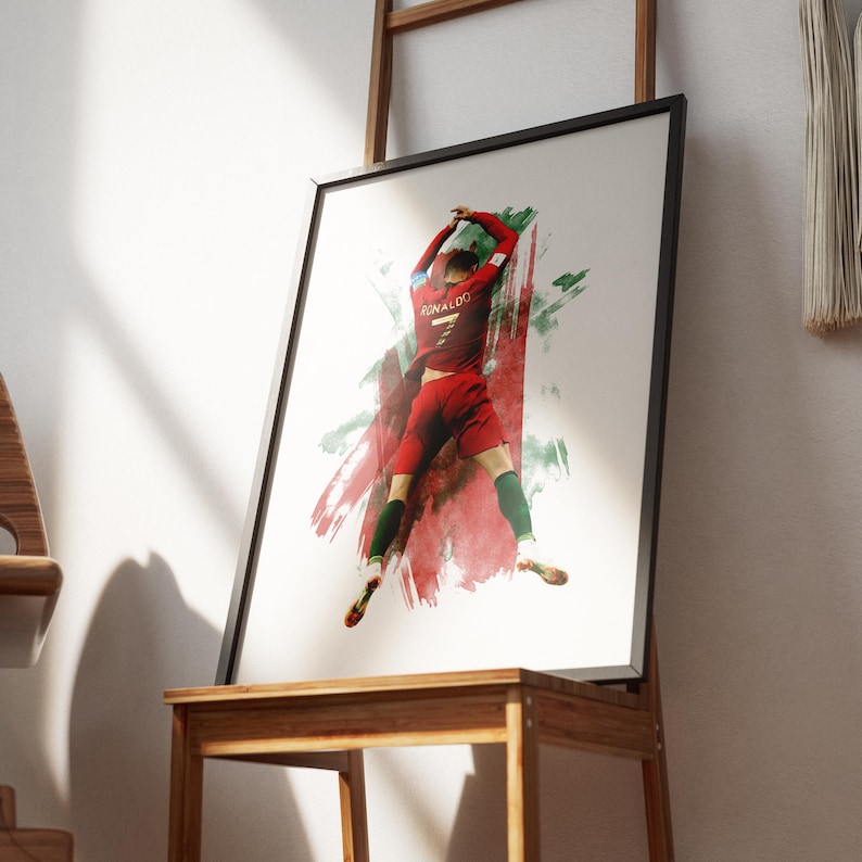 May include: A watercolor painting of a soccer player in a red and green jersey with the name "RONALDO" on the back. The player is in mid-air, celebrating a goal.