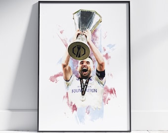 May include: Framed print of a soccer player celebrating with a trophy. The player is wearing a white jersey with the word "FOUNDATION" visible. The background features watercolor-style splashes of color.