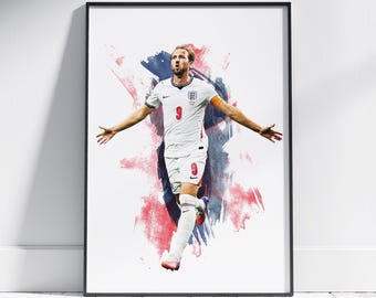 May include: A framed wall art print featuring a soccer player in a white England jersey with the number 9 in red, white shorts, and white socks. The player is depicted with arms outstretched against a background of blue and red watercolor splashes.