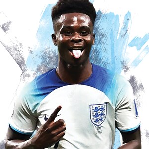 Puede incluir: Un joven con una camiseta de f&uacute;tbol blanca y azul con el escudo de Inglaterra en el pecho. Est&aacute; sacando la lengua y apuntando con el dedo &iacute;ndice derecho.