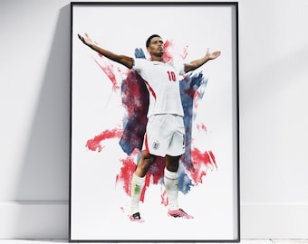 May include: A framed art print featuring a soccer player in a white England jersey with the number 10, arms outstretched in celebration. The background consists of abstract red and blue watercolor-style paint splashes on a white backdrop.
