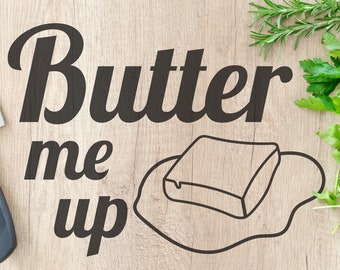 May include: A wooden cutting board with the text "Butter me up" in black lettering. A stick of butter is drawn on the board with a melted puddle around it. There is a black chef's knife and a bunch of fresh herbs in the background.