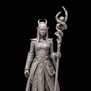 May include: A grey figurine of a fantasy character, possibly an elf, standing on a wooden platform. The character wears a long coat, armour, and boots, and holds a staff with a spiralling design. The figurine has pointed ears and a crown.