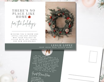May include: A green and white holiday postcard with a wreath and the text "There's no place like home for the holidays". The postcard also includes the text "Wishing you a warm and joyful holiday season. May your holiday be filled with joy, peace, and new beginnings." and the name "Leslie Lopez" with the title "Your Local Real Estate Agent".