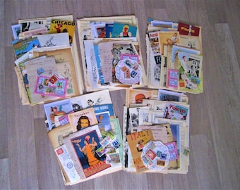 May include: A collection of vintage ephemera, including postcards, magazine clippings, and stamps, featuring travel destinations like Chicago, Paris, Hong Kong, and Tokyo. The papers are arranged in stacks on a wooden surface.