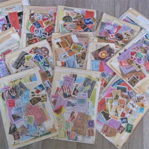 Puede incluir: Una colecci&oacute;n de ef&iacute;meras de papel vintage, incluyendo sellos, boletos y postales, dispuestas en pilas sobre una superficie de madera. Las ef&iacute;meras son de varios colores, incluyendo rojo, azul, verde y amarillo.