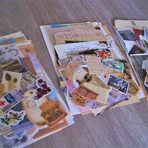 Puede incluir: Tres pilas de ef&iacute;meras vintage, que incluyen papel, tarjetas y pegatinas. Las ef&iacute;meras son de varios colores, incluyendo marr&oacute;n, blanco y azul. Las ef&iacute;meras presentan im&aacute;genes de flores, p&aacute;jaros y otros dise&ntilde;os inspirados en la naturaleza.